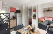 Casa móvil Comfort de tres dormitorios, cocina moderna, comedor y sala de estar en Camping Paradis Family des Issoux.