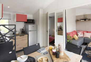 Comfort mobile home with three bedrooms, modern kitchen, dining area and lounge at Camping Paradis Family des Issoux.