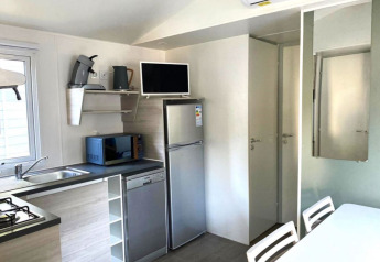 Moderne, kompakt køkkenplads i et Comfort Mobile Home på Camping Paradis Family des Issoux i Frankrig.