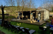 Buitenruimte met ligstoelen, terras en luxe stacaravan met jacuzzi op Camping Paradis Family des Issoux, Frankrijk.