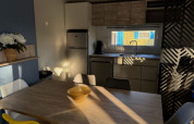 Moderne keuken en eetruimte met zonlicht in Paradijs Luxe Stacaravan bij Camping Paradis Family des Issoux.