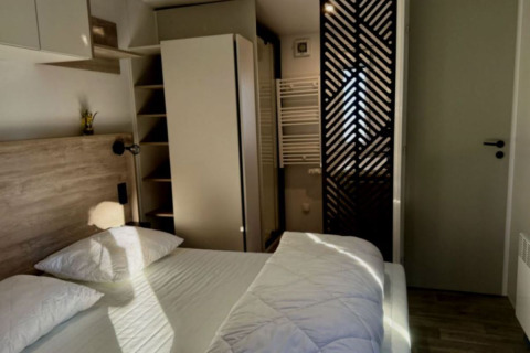 Slaapkamer in Paradijs Luxe Stacaravan met eigentijds interieur en zonlicht bij Camping Paradis Family des Issoux.
