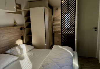 Slaapkamer in Paradijs Luxe Stacaravan met eigentijds interieur en zonlicht bij Camping Paradis Family des Issoux.