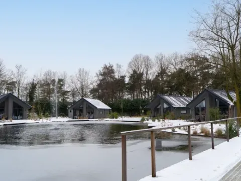 Chalets de vacances enneigés au bord d’un lac au parc Latour, North-Brabant, Pays-Bas, en hiver.