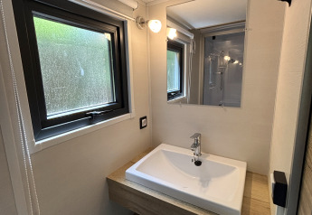 Moderno bagno compatto con lavabo e specchio nella Tiny House al Recreation Park de Paalberg, Paesi Bassi.