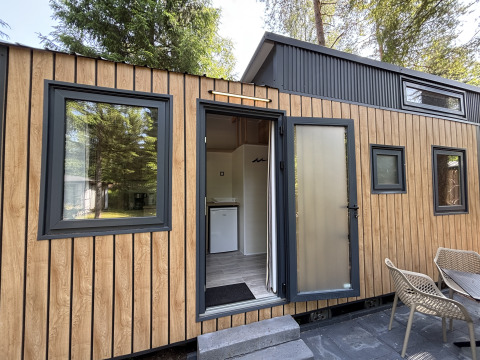 Udendørs billede af et Tiny House ved Recreation Park de Paalberg i Holland med terrasse og stole.