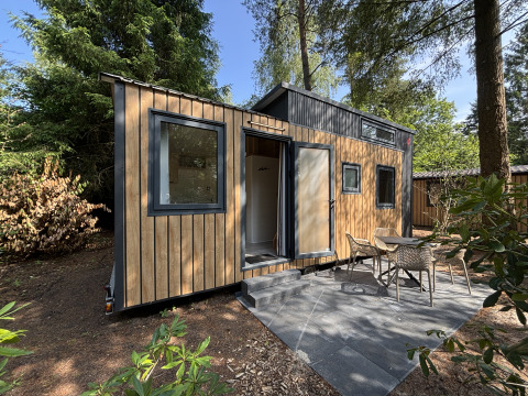 Lille træhus med terrasse og havemøbler i skoven, Tiny House ved Rekreationspark de Paalberg, Holland.