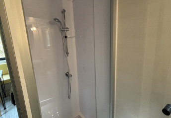 Cabine de douche moderne dans une tiny house au Parc de Loisirs de Paalberg, Pays-Bas, avec porte vitrée.