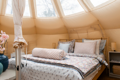 Innenaufnahme eines gemütlichen Lotus Belle Safari-Zeltes mit Doppelbett und stilvoller Einrichtung.