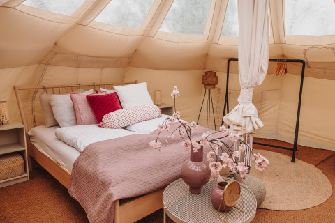 Intérieur d'une tente safari Lotus Belle au parc De Achterste Hoef, Pays-Bas, avec lit confortable.