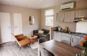 Salon moderne et cuisine dans un chalet de luxe au parc de loisirs De Achterste Hoef, aux Pays-Bas.