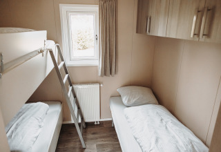 Et lyst og hyggeligt værelse med køjeseng og enkeltseng i luksuschalet på De Achterste Hoef, Holland.
