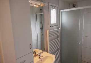 Modernes Badezimmer im Luxury Chalet im Freizeitpark De Achterste Hoef mit Dusche und Spiegel.
