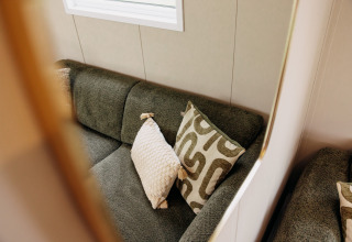 Canapé confortable avec coussins design dans un chalet de luxe au parc de loisirs De Achterste Hoef, Pays-Bas.