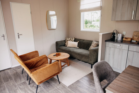 Salon moderne dans un chalet de luxe au parc De Achterste Hoef, Pays-Bas, avec une ambiance chaleureuse.