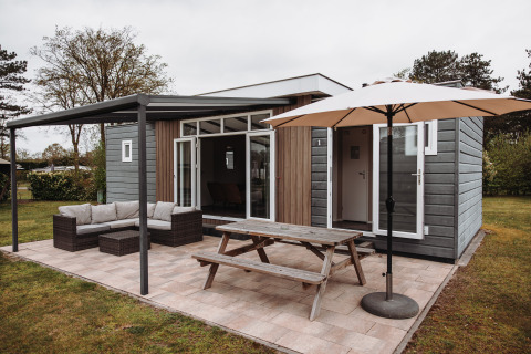Chalet de luxe avec terrasse, salons de jardin et parasol au parc de loisirs De Achterste Hoef aux Pays-Bas.