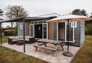 Chalet de luxe avec terrasse, salons de jardin et parasol au parc de loisirs De Achterste Hoef aux Pays-Bas.