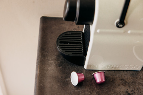 Gros plan d'une machine Nespresso avec deux capsules roses dans un chalet de luxe à De Achterste Hoef, Pays-Bas.