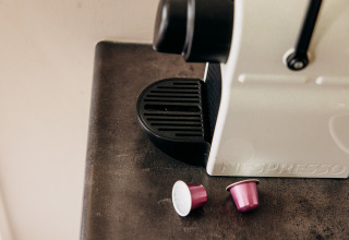 Gros plan d'une machine Nespresso avec deux capsules roses dans un chalet de luxe à De Achterste Hoef, Pays-Bas.