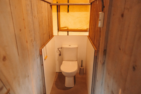 Baño con inodoro en tienda safari en el parque de recreo De Achterste Hoef, Países Bajos, diseño rústico.