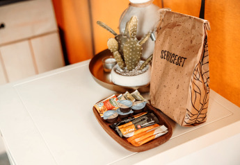 Service-sæt og snacks på hvidt bord i safaritelten ved Recreatiepark De Achterste Hoef, Holland.