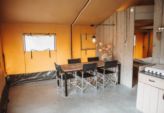 Vista interior de la sala comedor de una tienda safari con muebles de madera en De Achterste Hoef, Países Bajos.