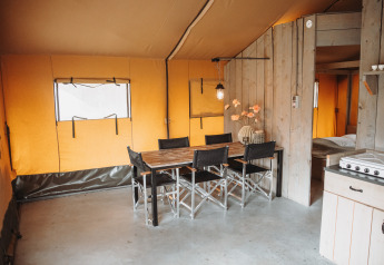Innenansicht eines Safari-Zeltes mit Esstisch und Stühlen im Erholungspark De Achterste Hoef, Niederlande.