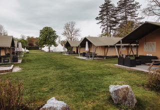 Safari tents and green lawn at Recreation park De Achterste Hoef in the Netherlands on a cloudy day.