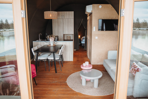 Vue intérieure d’un lodge aquatique au parc de loisirs De Achterste Hoef, Pays-Bas, avec mobilier moderne.