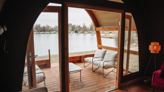Zicht vanuit de Water Lodge bij recreatiepark De Achterste Hoef in Nederland op terras en meer.