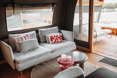 Moderne sofa og udendørs siddeplads i en vandhytte ved Recreatiepark De Achterste Hoef, Holland.