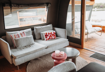 Cozy sofa and outdoor seating area inside the water lodge at Recreation park De Achterste Hoef, Netherlands.