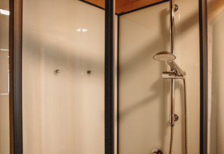 Moderne Duschkabine mit Glastüren in der Water Lodge im Erholungspark De Achterste Hoef, Niederlande.