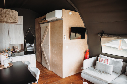 Vue intérieure d'une Water lodge confortable au parc De Achterste Hoef aux Pays-Bas, avec mobilier moderne.