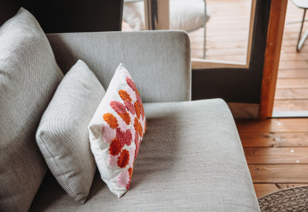 Cozy grey sofa with decorative cushions in Water Lodge at Recreation Park De Achterste Hoef, Netherlands.
