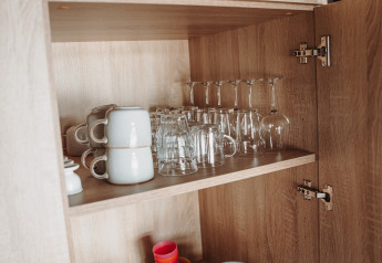 Placard ouvert avec assiettes, tasses et verres à la Water lodge du parc De Achterste Hoef aux Pays-Bas.