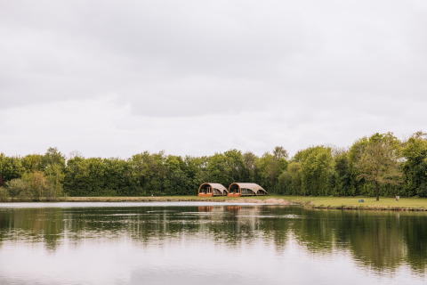 Uitzicht op de Water lodge aan het recreatiepark De Achterste Hoef in Nederland, bij een rustig meer.
