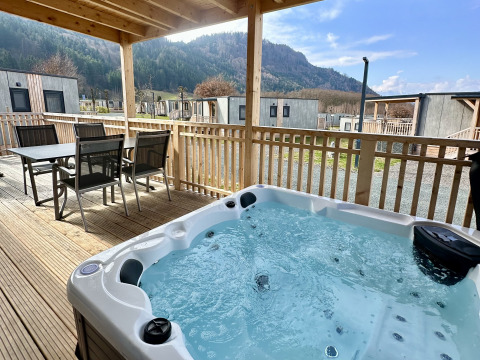 Buitenterras bij Enzian-lodge, Ossiacher See, Oostenrijk, met jacuzzi en uitzicht op de bergen.