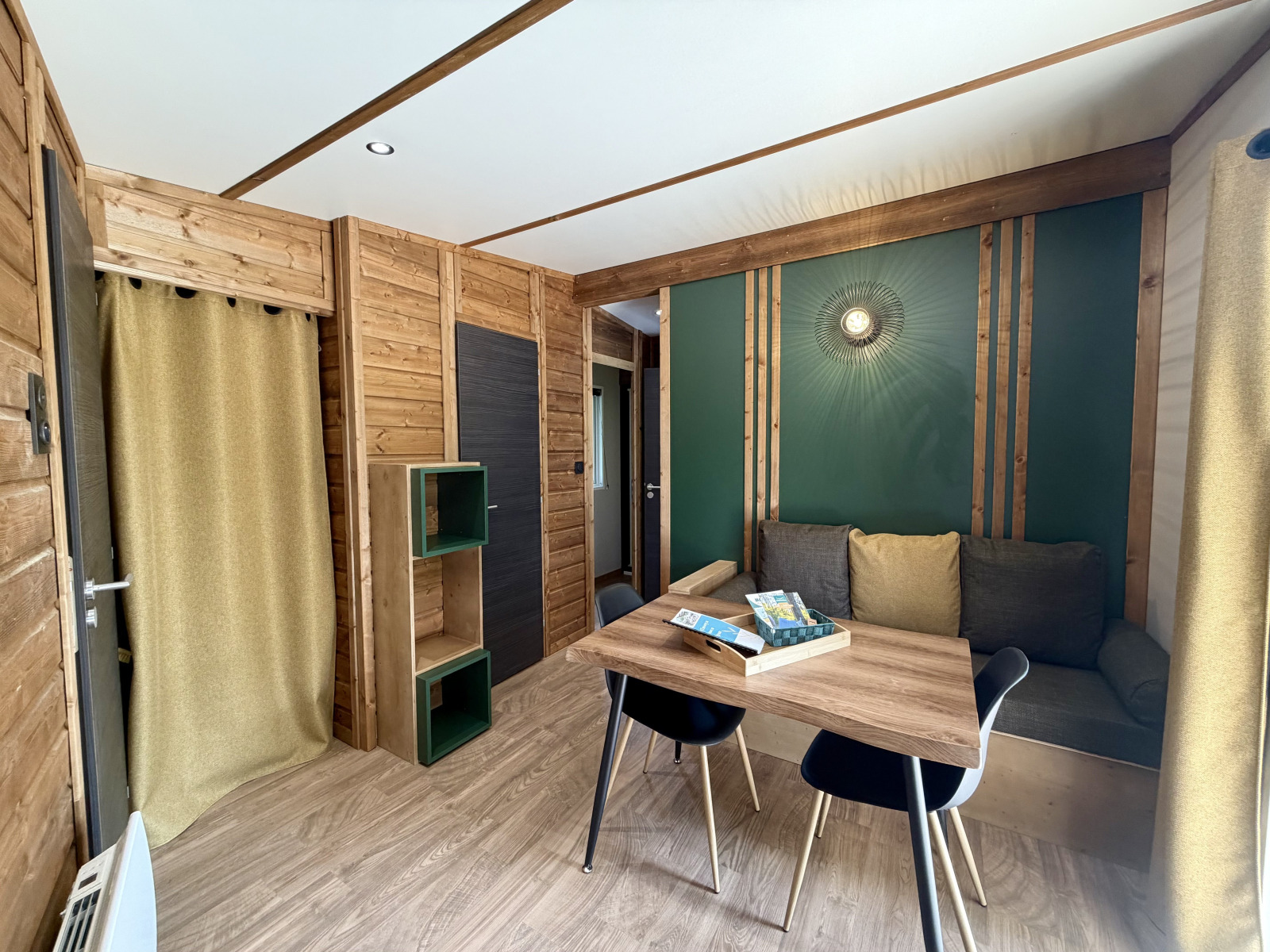 Interieurfoto van een knusse lodge bij La Clairiere, Campsite Seasonova Ensoya, Frankrijk, met houten wanden en bank.