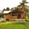 Glamping accommodation at Castel Camping le Brevedent in Normandy with a safari tent, hammock, and garden.