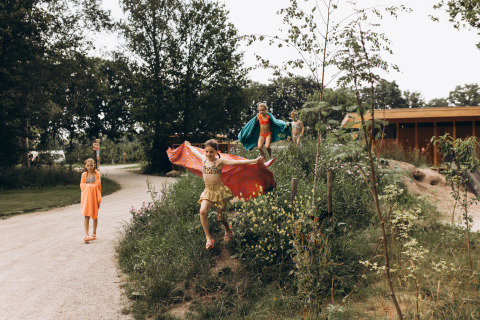 Des enfants jouent dehors sur des collines herbeuses au Camping De Kleine Wereld, à Groningen, Pays-Bas.