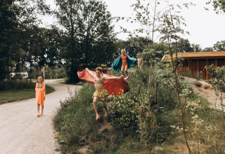 Niños juegan al aire libre en colinas verdes en Camping De Kleine Wereld, un parque de vacaciones en Groningen, Países Bajos.