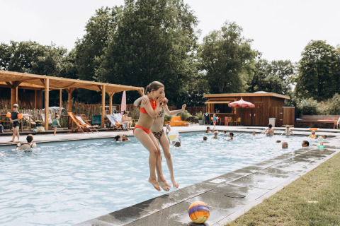Niños saltan a la piscina en Camping 'De Kleine Wereld', un parque vacacional en Groningen, Países Bajos.