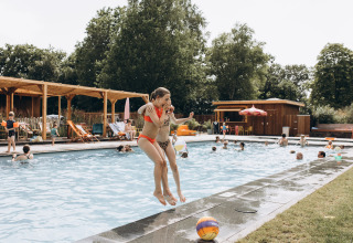 Niños saltan a la piscina en Camping 'De Kleine Wereld', un parque vacacional en Groningen, Países Bajos.