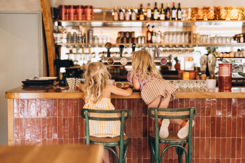 Zwei kleine Kinder sitzen an der Bar des Campingplatzes De Kleine Wereld in Groningen, Niederlande.