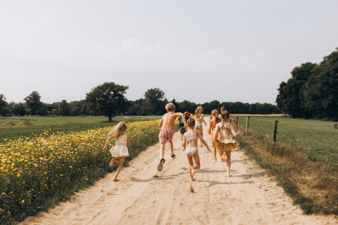 Des enfants courent sur un chemin sablonneux près des champs de fleurs à Onnen, Groningue, aux Pays-Bas.