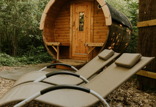 Ronde houten sauna en twee ligbedden in bos bij Luxe bosrand loft, Si-Es-An, Nederland.