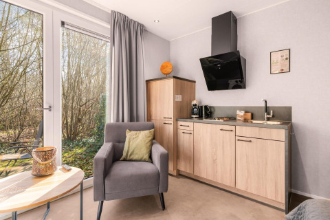 Gezellig natuurhuisje met kitchenette, zetel en uitzicht op het bos bij Camping Si-Es-An in Nederland.
