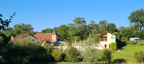 Uitzicht op Domaine Papillon vakantiepark in Occitanië, Frankrijk, omgeven door bomen en groene heuvels.