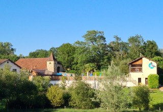 Vue du parc de vacances Domaine Papillon en Occitanie, France, entouré d’arbres et de collines verdoyantes.